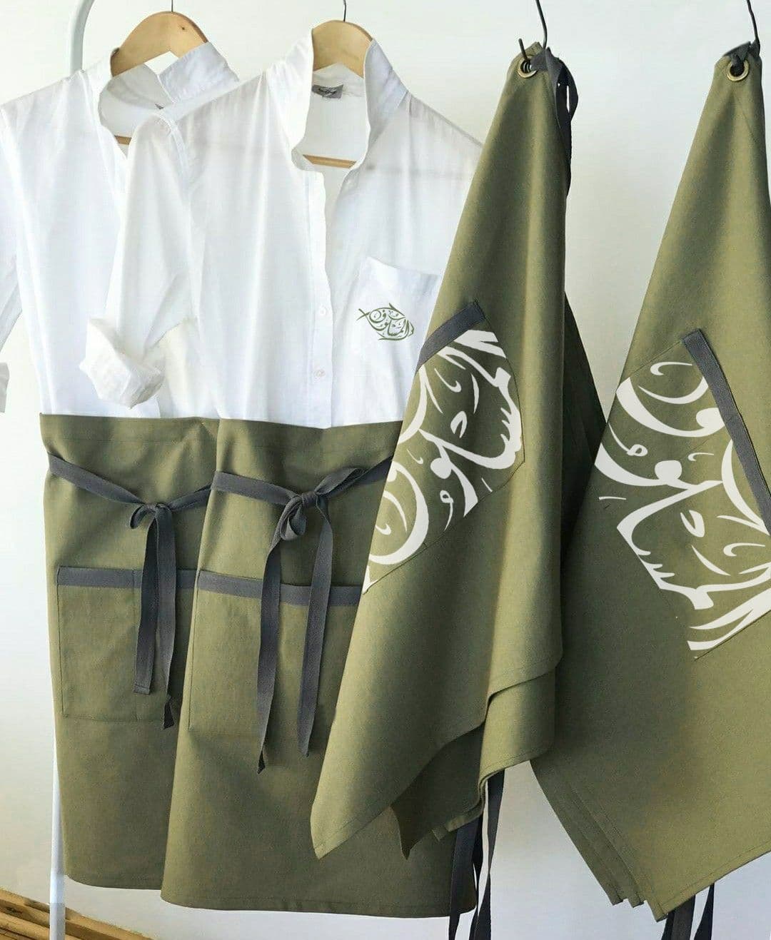 The Maskoof uniform — olive aprons printed with calligraphy